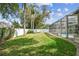 Spacious backyard with a neat lawn, a white privacy fence, and glimpses of the pool area at 1521 Brittany Ct, New Port Richey, FL 34655