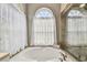 Luxurious soaking tub in bathroom with large window and tile surround at 1521 Brittany Ct, New Port Richey, FL 34655