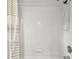 Tiled shower with a showerhead and tan and white patterned curtain at 1521 Brittany Ct, New Port Richey, FL 34655