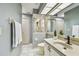 Bright bathroom featuring a tiled shower, white tiled floor, and spacious vanity at 1521 Brittany Ct, New Port Richey, FL 34655