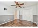 Bedroom features wood floors, a ceiling fan, and double closet at 1521 Brittany Ct, New Port Richey, FL 34655