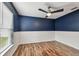 This bedroom offers a ceiling fan, a window and a combination of wood and carpet floors at 1521 Brittany Ct, New Port Richey, FL 34655