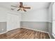 Bedroom features wood floors, ceiling fan, and double closet at 1521 Brittany Ct, New Port Richey, FL 34655