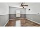 Wood floors, a ceiling fan, and a wainscoting design adorn this bedroom at 1521 Brittany Ct, New Port Richey, FL 34655