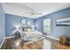 Blue bedroom with wood floors, ceiling fan, and a window with natural light at 1521 Brittany Ct, New Port Richey, FL 34655