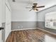 Bedroom features wood floors, ceiling fan, window, and wainscoting at 1521 Brittany Ct, New Port Richey, FL 34655