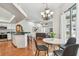 Open-concept dining area seamlessly connects kitchen and living spaces, complete with chandelier and backyard views at 1521 Brittany Ct, New Port Richey, FL 34655