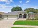 Charming single-story home with a three-car garage, manicured lawn, and inviting brick-paved driveway at 1521 Brittany Ct, New Port Richey, FL 34655