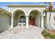 Inviting front porch with stately columns, arched entryways, and brick-paved sitting area at 1521 Brittany Ct, New Port Richey, FL 34655