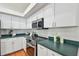 Well-lit kitchen featuring stainless steel appliances, ample counter space, and white cabinetry for a modern aesthetic at 1521 Brittany Ct, New Port Richey, FL 34655