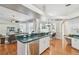 Sunlit kitchen island with bar seating flows into a comfortable living area for seamless entertaining and relaxation at 1521 Brittany Ct, New Port Richey, FL 34655