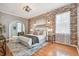 Main bedroom featuring a brick accent wall, ceiling fan, and ensuite at 1521 Brittany Ct, New Port Richey, FL 34655