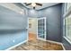 Bright home office with wood floors, blue walls, and a door leading to another room at 1521 Brittany Ct, New Port Richey, FL 34655