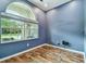 Cozy blue room with wood-look floors and large window offering a peaceful view at 1521 Brittany Ct, New Port Richey, FL 34655