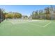 Close-up shot of a well-maintained tennis court surrounded by a chain-link fence at 1521 Brittany Ct, New Port Richey, FL 34655