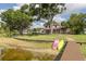 Lush backyard with a path leading to the lakefront, complete with paddleboards and a dock at 1834 Daiquiri Ln, Lutz, FL 33549