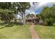 Spacious backyard with brick path leading to the house and a pool overlooking the lake at 1834 Daiquiri Ln, Lutz, FL 33549