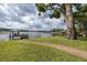 Lush backyard with brick walkway leading to a covered dock on a serene lake at 1834 Daiquiri Ln, Lutz, FL 33549