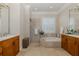 Spacious bathroom featuring a soaking tub, separate shower, dual sinks, and light tile flooring at 1834 Daiquiri Ln, Lutz, FL 33549
