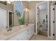 Bright bathroom featuring a double sink vanity, an oval window, and a connecting door at 1834 Daiquiri Ln, Lutz, FL 33549