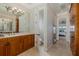 Bathroom showcasing a wood vanity, mirror, and view of the bedroom suite at 1834 Daiquiri Ln, Lutz, FL 33549