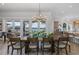 Elegant dining area featuring a statement chandelier, a large wooden table, and access to the pool at 1834 Daiquiri Ln, Lutz, FL 33549