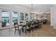 Open dining room with lake views, a modern chandelier, and a large wood table set for ten at 1834 Daiquiri Ln, Lutz, FL 33549