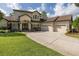 Elegant elevation showing a three-car garage, and a manicured lawn at 1834 Daiquiri Ln, Lutz, FL 33549