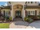 Inviting front entrance features double doors, charming sconces, and lush landscaping at 1834 Daiquiri Ln, Lutz, FL 33549