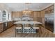 Spacious kitchen boasting a large island with counter seating, natural wood cabinets, and herringbone floors at 1834 Daiquiri Ln, Lutz, FL 33549