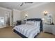 Bright bedroom features a ceiling fan, side tables, and a peek into the ensuite bathroom at 1834 Daiquiri Ln, Lutz, FL 33549