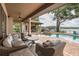 Inviting covered patio with a pool, fireplace, and lake view offers the ultimate outdoor living experience at 1834 Daiquiri Ln, Lutz, FL 33549