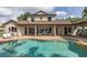 Relaxing backyard oasis featuring a beautiful private pool, brick pool deck, and covered seating area at 1834 Daiquiri Ln, Lutz, FL 33549