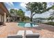 A picturesque pool overlooking a serene lake, surrounded by lush greenery and chaise lounges at 1834 Daiquiri Ln, Lutz, FL 33549