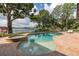 Backyard pool and spa with lake view, surrounded by lush landscaping at 1834 Daiquiri Ln, Lutz, FL 33549