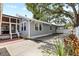 Charming home exterior with a screened-in patio, lush trees, and a private driveway at 212 W Powhatan Ave, Tampa, FL 33604