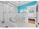 A view of a bathroom, featuring white subway tile, a clawfoot tub, and beadboard paneling at 212 W Powhatan Ave, Tampa, FL 33604