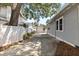 Long driveway between house and fence, leading to a detached garage with landscaping at 212 W Powhatan Ave, Tampa, FL 33604