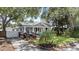 Charming bungalow-style home with a welcoming front porch, lush landscaping, driveway and fenced area at 212 W Powhatan Ave, Tampa, FL 33604