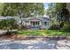 Charming bungalow-style home with a welcoming front porch, lush landscaping, and classic architectural details at 212 W Powhatan Ave, Tampa, FL 33604
