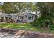 Charming bungalow-style home with a welcoming front porch, lush landscaping, and classic architectural details at 212 W Powhatan Ave, Tampa, FL 33604