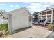 Detached garage with white door is accessible via a brick walkway to the screened pool area at 212 W Powhatan Ave, Tampa, FL 33604