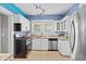 Updated kitchen features white cabinets, stainless steel appliances, and a mosaic backsplash at 212 W Powhatan Ave, Tampa, FL 33604
