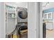 Efficient laundry area including a stacked washer and dryer, next to the kitchen at 212 W Powhatan Ave, Tampa, FL 33604
