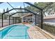 A screened pool with lounge chairs and a covered porch create a relaxing outdoor oasis at 212 W Powhatan Ave, Tampa, FL 33604