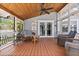 Inviting screened-in porch featuring wood floors, ceiling fan, and comfortable wicker furniture at 212 W Powhatan Ave, Tampa, FL 33604