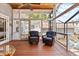 Comfortable screened porch featuring wood floors, wicker furniture, and access to the pool at 212 W Powhatan Ave, Tampa, FL 33604