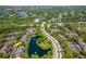 Picturesque aerial view of community, with a lake surrounded by lush trees and homes at 2173 Tuscany Trce # 8, Palm Harbor, FL 34683