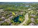 Stunning aerial shot showcases a home's proximity to a peaceful pond within a tree-filled community at 2173 Tuscany Trce # 8, Palm Harbor, FL 34683