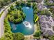Community aerial view showcasing the scenic lake, mature trees, and building at 2173 Tuscany Trce # 8, Palm Harbor, FL 34683